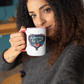 Smiling woman holding 'America In Heart' patriotic mug in cozy indoor setting